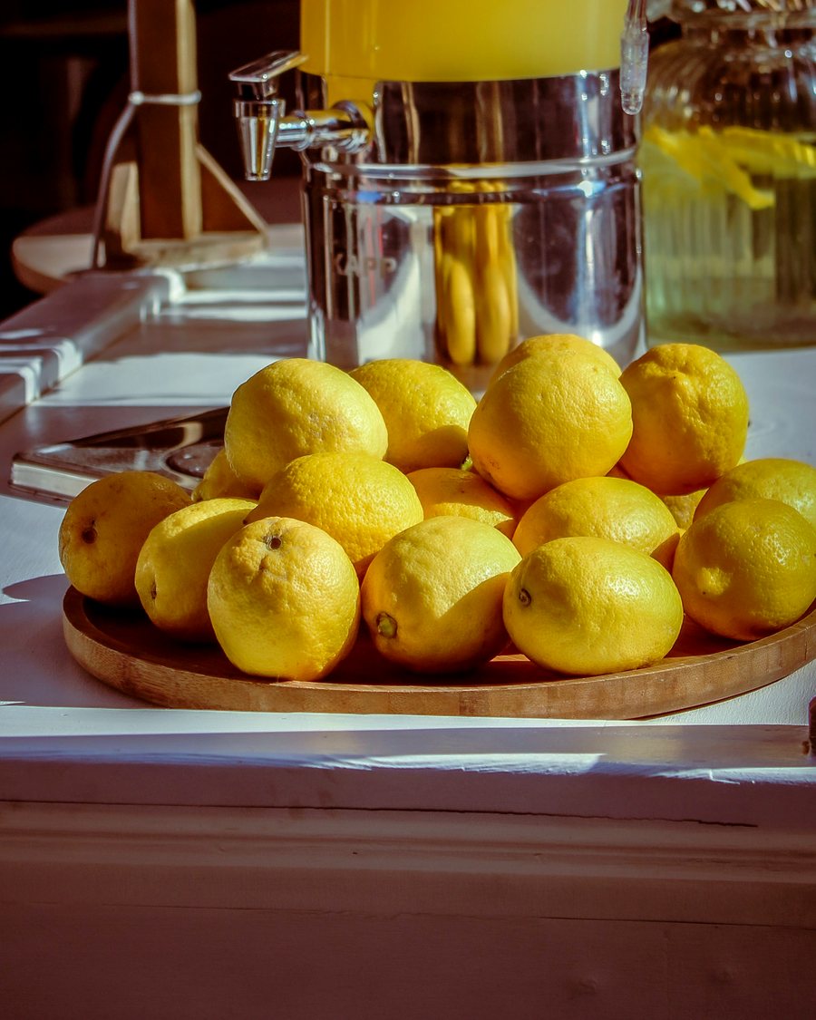 Fresh lemons and a lemonade dispenser at a market stall